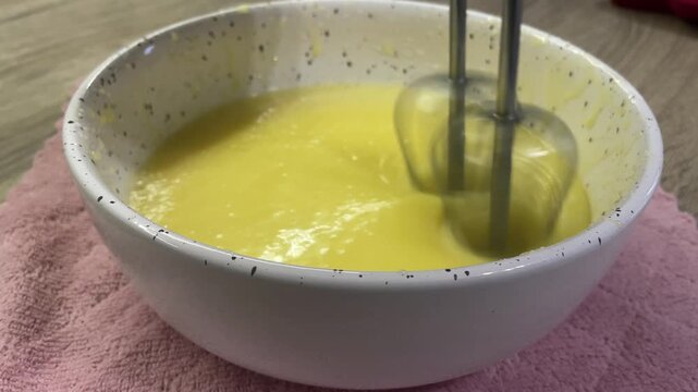 Mixing yolks and butter. Realistic baking process on clean white background.