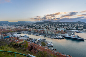 Fototapeta premium Sunrise just before golden hour starts in the harbour of Nice with luxury private boats and the beautiful houses on the shore. This is the place were the rich people meet.