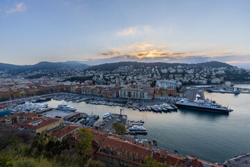 Obraz premium Sunrise just before golden hour starts in the harbour of Nice with luxury private boats and the beautiful houses on the shore. This is the place were the rich people meet.