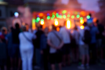 Blurred background. A city festival with people. Evening concert. A festive event. Crowd.