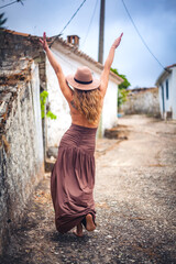 Woman exploring traditional village street in Algarve, Portugal