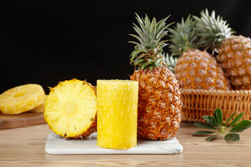 Fresh Golden Pineapple Slices and Whole Tropical Fruit on Wooden Table
