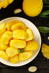 Fresh Hainan Pineapple Slices in Bowl with Tropical Juice on Wooden Background