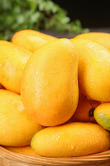 Fresh Tainong Mangoes from Hainan China - Golden Tropical Fruit with Water Droplets in Wooden Bowl