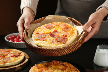Homemade bacon and ham pizza in wicker basket - delicious Italian food with melted cheese