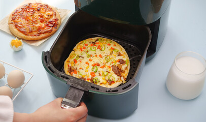 Fresh Pizza with Cheese and Ham Cooking in Air Fryer - Modern Kitchen Appliance Food Preparation