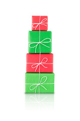 Pile of red and green wrapped gift boxes tied with white string, isolated on transparent background with reflection. Stock photo.