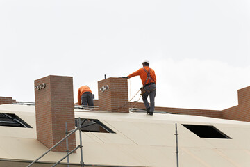 Obreros trabajando en la construcción del tejado de un edificio.