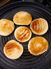Handmade glutinous rice cakes frying on grill pan - traditional Asian sweet treats cooking