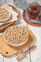 Dried Chickpeas and Peas in Wooden Bowls with Tea Glass on Rustic Table - Healthy Legume Food Showcase