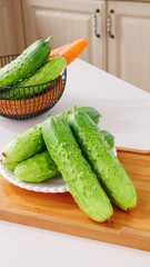 Fresh Green Cucumbers and Carrots in Modern Kitchen - Healthy Vegetables on Cutting Board