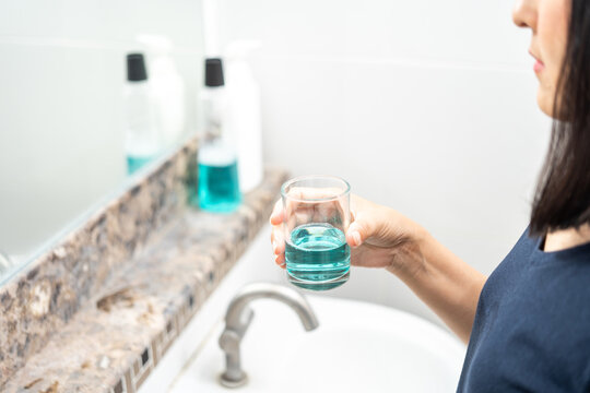 Woman healthy using mouthwash after brushing her teeth fresh breath. Oral hygiene routine for freshness breath, prevent plaque and gum disease. Dental health care Oral hygiene and teeth care concept.