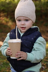 A child with a glass of coffee on the street