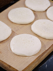 Handmade Raw Dough Rounds on Wooden Board Ready for Baking - Traditional Food Preparation