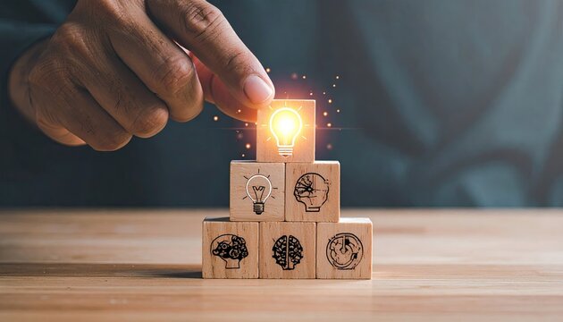 Hand placing lightbulb block on top of a wooden block pyramid, featuring brain icons