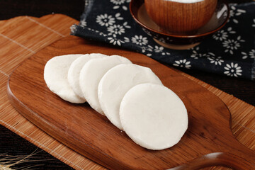 Sliced White Rice Cakes on Wooden Board with Traditional Tea Setting