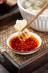 Freshly Cooked Handmade Dumpling with Spicy Sauce and Chopsticks on Wooden Tray