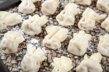 Handmade Goldfish Wontons Dusted with Flour on Bamboo Mat Ready for Cooking