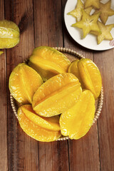 Yellow Star Fruit Slices in Wicker Basket on Wooden Table - Fresh Tropical Fruit from Fujian Zhangzhou China