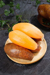 Fresh Ripe Papaya Fruit Slices on Wooden Plate with Natural Stone Background