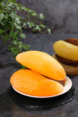 Fresh Yellow Mango Slices on Plate with Tropical Fruit Bowl Dark Slate Background