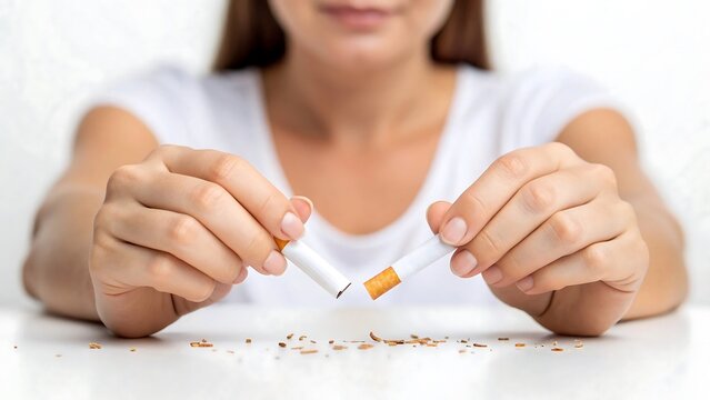 Close up of woman’s hands breaking cigarette as stop smoking concept
