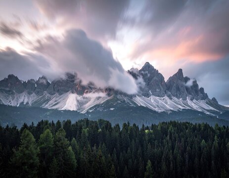 Dramatic mountain range at sunset, shrouded in clouds