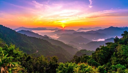 Sunrise over misty mountain range. Lush valleys and forests