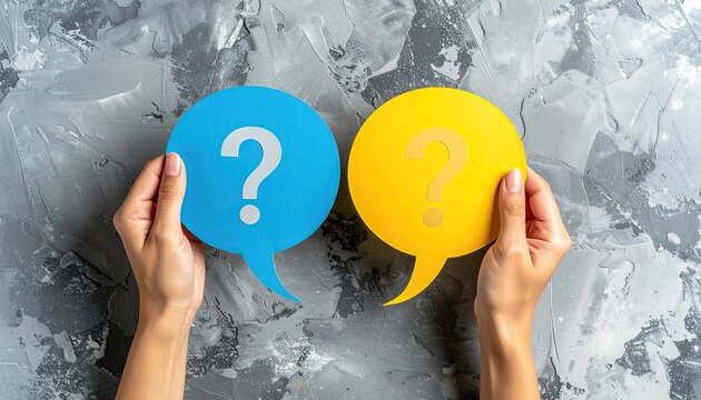 Two hands hold question mark speech bubbles, blue and yellow, against a gray textured background - Powered by Adobe