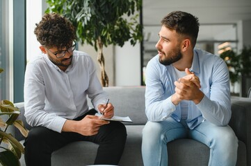 Psychologist taking notes while listening to patient talking about problems