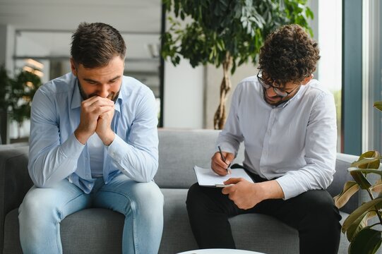 Psychologist taking notes while listening to patient talking about problems