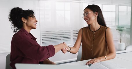 Happy young diverse business professional women shaking hands at table - Powered by Adobe