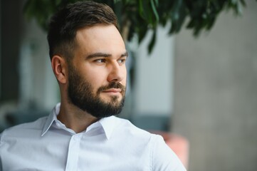 Pensive businessman reflecting in modern office setting