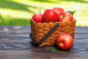 Basket of ripe red apples on a wooden table