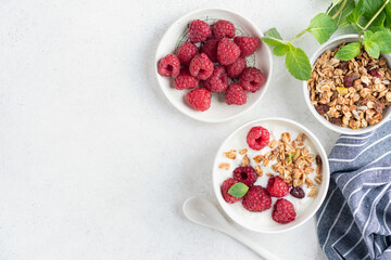 Muesli with raspberries and yogurt on grey concrete table background. Healthy diet fitness meal. top view copy space