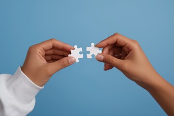 Diverse hands holding puzzle pieces on blue background