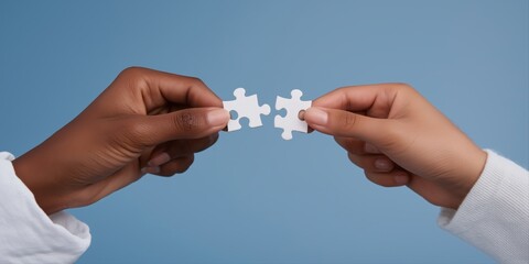 Fototapeta premium Hands of diverse individuals connecting puzzle pieces on blue background