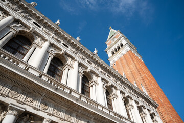View from below of the bell tower of Venice with the adjacent historic building.