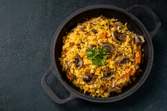 Mushroom pilaf with rice in cast iron pan top view