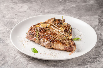 Grilled ribeye steak with garlic and herbs on plate