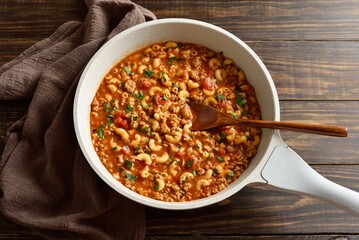 Dish with ground beef, vegetables and pasta in tomato sauce in cooking pan