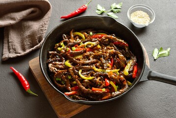 Chinese style skillet of fried thinly sliced into strips beef and peppers