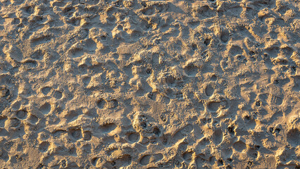 The red beach sand is imprinted with numerous
