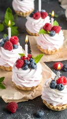 Birthday cakes with berries and candles