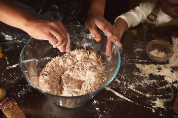 Family Baking Together: Hands Mixing Flour in Large Glass Bowl for Fresh Dough