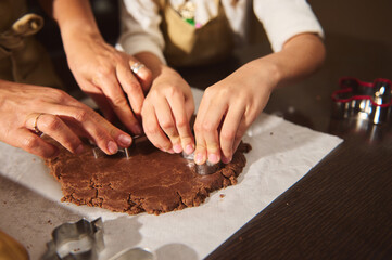 Family Baking Gingerbread Cookies Together: Hands Cutting Dough On Kitchen Table