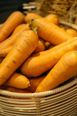 Vibrantly colored orange carrots neatly stacked in a woven basket, symbolizing freshness and healthy nourishment