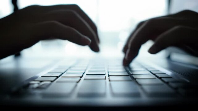 low-angle, ecu macro video of nimble fingers typing rapidly on a dark laptop keyboard, reflecting iridescent screen glow. blurred modern workspace with bokeh, concept of focused digital productivity