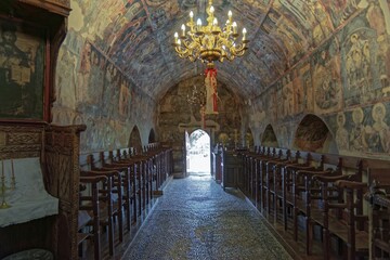 Historic church interior with paintings and a decorative chandelier, conveying a calm and venerable atmosphere, Greek Orthodox Church Kimisis tis Theotokou, Asklipiio, Rhodes Island, Greece