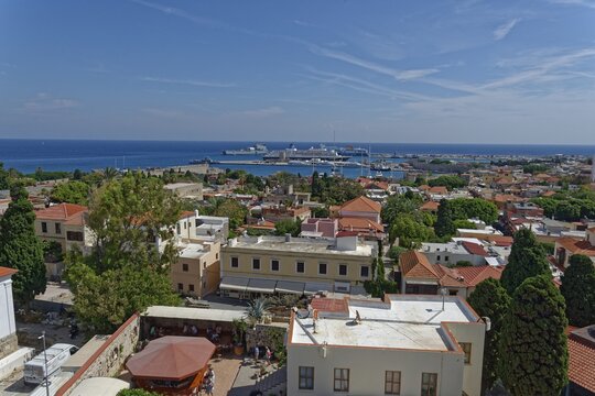 Overview of a town on the coast with harbour, many buildings and trees, Roloi Clock Tower, Medieval Town of Rhodes, Rhodes Island, Greece